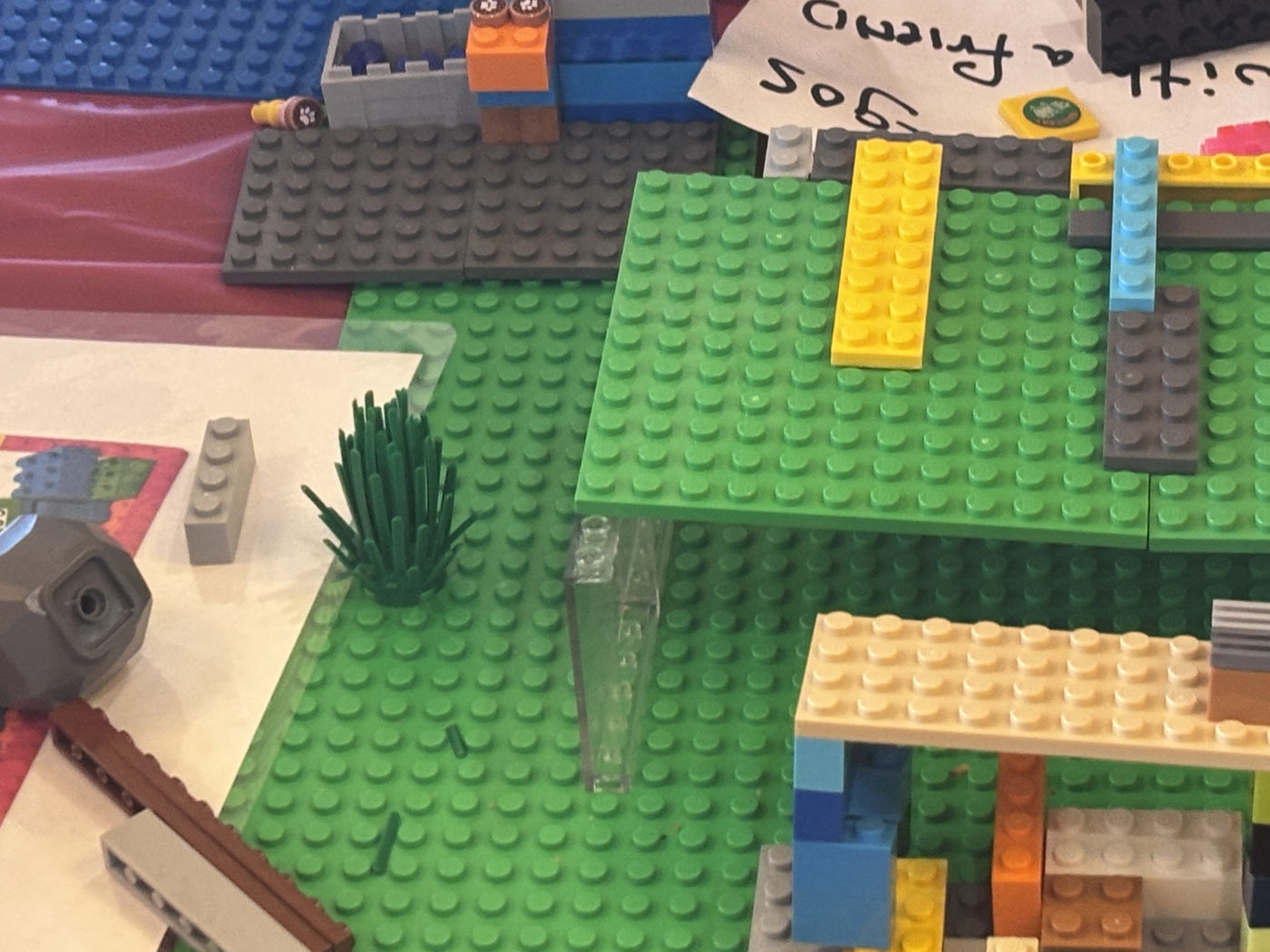 Green LEGO baseplates raised on supports above a lower level